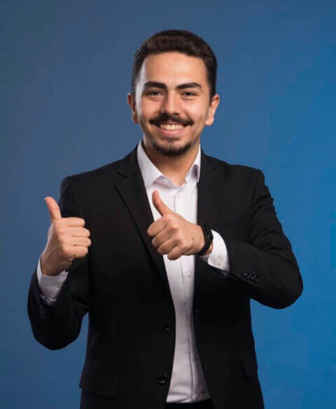 Businessman in black suit makes thumbs up (1)